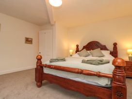 A bedroom with a wooden bed and nightstands with lamps at Bellmanear Farm Cottage in North Grimston near Malton