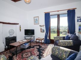 A living room with a television and sofa at The Hayloft in Common Moor near Liskeard