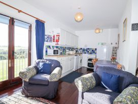 A kitchen with cabinets and a dining table at The Hayloft in Common Moor near Liskeard