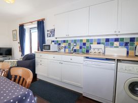 A kitchen with cabinets and appliances at The Hayloft in Common Moor near Liskeard