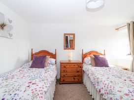 A bedroom with two single beds and a dresser at The Hayloft in Common Moor near Liskeard