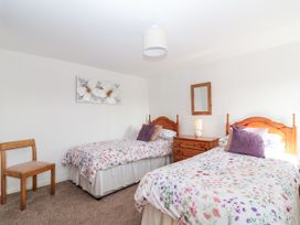 A bedroom with two single beds and a small dresser at The Hayloft Common Moor near Liskeard