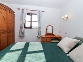 A bedroom with a bed and wardrobe at The Hayloft in Common Moor near Liskeard