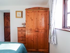 A bedroom with a wardrobe and a chest of drawers at The Hayloft in Common Moor near Liskeard