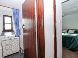 A bedroom with a bed and window leading to another room at The Hayloft Common Moor near Liskeard
