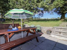 An outdoor patio with a table and chairs at The Hayloft in Common Moor near Liskeard
