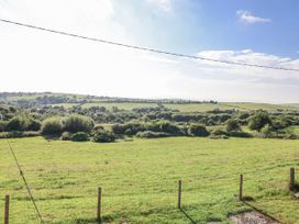 A view of a field with trees and hills at The Hayloft in Common Moor near Liskeard