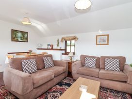 A living room with sofas and a table at The Dairy in Common Moor near Liskeard