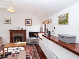 A living room with a fireplace and television at The Dairy in Common Moor near Liskeard