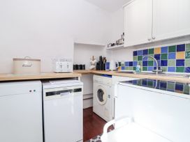 A kitchen with appliances and a tiled backsplash at The Dairy Common Moor near Liskeard