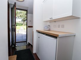 A utility room with a worktop and fridge at The Dairy in Common Moor near Liskeard