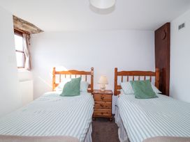 A bedroom with two single beds and a nightstand at The Dairy Common Moor near Liskeard