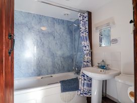 A bathroom with a bathtub, sink, and toilet at The Dairy in Common Moor near Liskeard