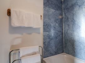 A bathroom with towels on a rack and a bathtub at The Dairy in Common Moor near Liskeard