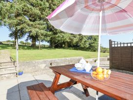 A picnic table with an umbrella and fruit bowl at The Dairy Common Moor near Liskeard