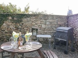 An outdoor dining setup with a grill and table at The Dairy Common Moor near Liskeard