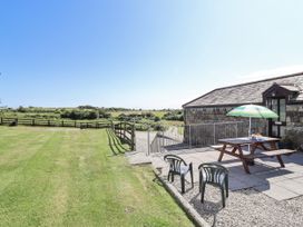 An outdoor area with a table and chairs at The Byre in Common Moor near Liskeard