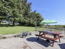 A picnic table with an umbrella in an outdoor area at The Byre Common Moor near Liskeard