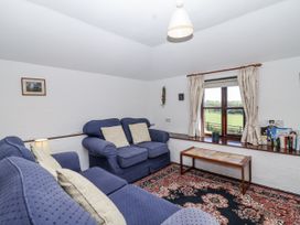 A living room with a sofa and window overlooking fields at The Byre Common Moor near Liskeard