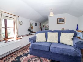 A living room with a blue sofa and various decorations at The Byre Common Moor near Liskeard