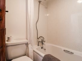 A bathroom with a bathtub, toilet, and shower at The Byre in Common Moor near Liskeard