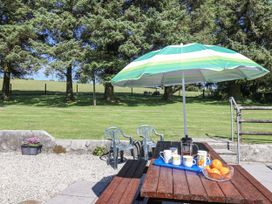 An outdoor seating area with a table and chairs at The Byre in Common Moor near Liskeard