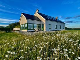 A house with solar panels and daisies in the garden at Lighthouse Hill in Mulranny, County Mayo