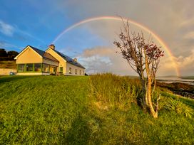 A house with a rainbow in the sky at Lighthouse Hill in Mulranny, County Mayo