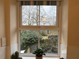 A kitchen window with plants overlooking a garden at Rothay Cottage Ambleside