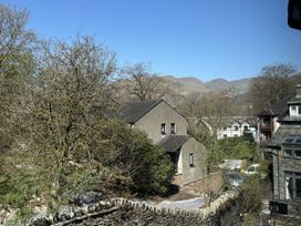 A view of houses and trees with mountains in the background at Rothay Cottage Ambleside