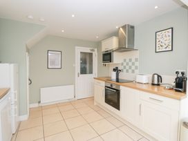 A kitchen with appliances and a door at Rothay Cottage Ambleside