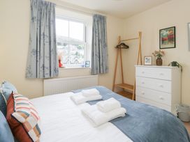 A bedroom with a bed and dresser at Rothay Cottage in Ambleside