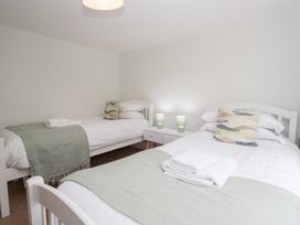 A bedroom with two beds and bedside tables at Rothay Cottage in Ambleside