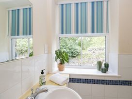 A bathroom with a sink and plants on a windowsill at Rothay Cottage in Ambleside