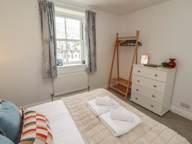 A bedroom with a bed and dressers at Rothay Cottage in Ambleside