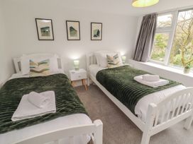 A bedroom with two beds and a window at Rothay Cottage in Ambleside