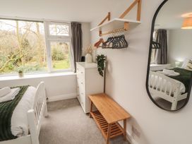 A bedroom with a bed and dresser at Rothay Cottage in Ambleside