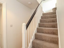 A staircase with carpet and handrail at Rothay Cottage in Ambleside