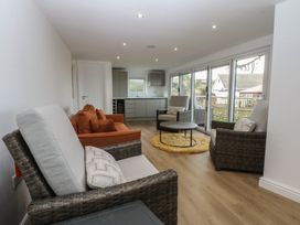 A sunroom with seating and kitchen area at The Bay in Benllech