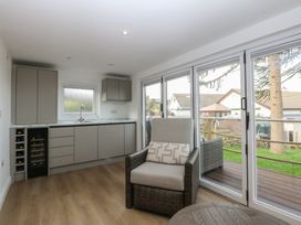 A kitchen with cabinets and a chair at The Bay in Benllech