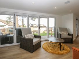 A living room with chairs and a table at The Bay in Benllech