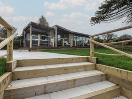 A view of steps leading to a building with large windows at The Bay in Benllech