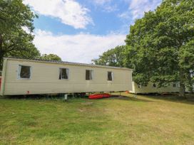 Two mobile homes parked on grass with trees around at Greenwood in Cowes