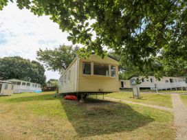 A group of mobile homes on a grassy hill with trees around at Greenwood in Cowes