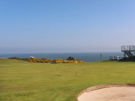 An outdoor golf course overlooking the ocean at Gwynlys in Cemaes Bay