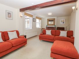 A living room with sofas and a fireplace at Iona Cottage Southwold