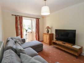 A living room with a sofa and television at Iona Cottage in Southwold