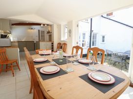 A dining room with a table set for meals at Iona Cottage Southwold