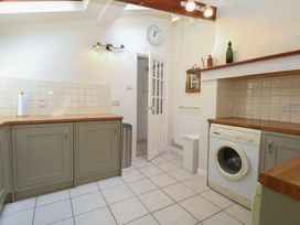 A laundry room with a washing machine and cabinets at Iona Cottage Southwold