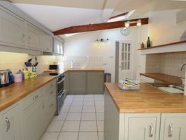 A kitchen with cabinets, countertops, and appliances at Iona Cottage Southwold